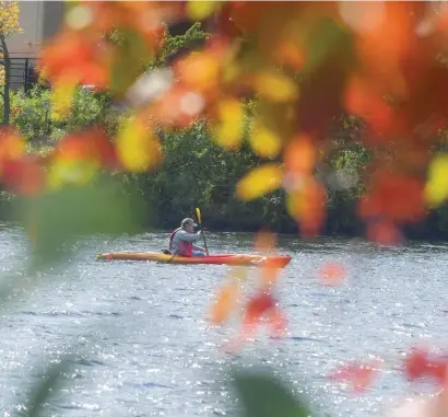  ?? JIM MICHAuD / boSton HerAlD ?? PLEASANT VOYAGE: There was a cooler feel Sunday after the warm days we have been having, as a man kayaks on Sunday on the Charles River in Cambridge where crew teams will be out in force next weekend during the annual Head of the Charles Regatta.