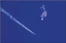  ?? CHAD FISH VIA AP, FILE ?? The remnants of a large balloon drift above the Atlantic Ocean, just off the coast of South Carolina, with a fighter jet and its contrail seen below it, on Saturday.