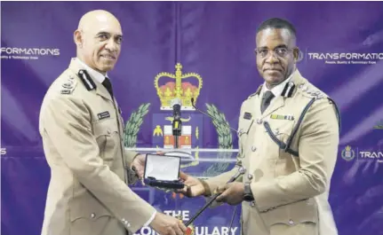  ?? (Photo: Naphtali Junior) ?? Outgoing Commission­er of Police Major General Antony Anderson (left) hands over items including a special pen to his successor, Dr Kevin Blake. The occasion was the changing of command ceremony on Monday.