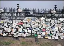  ?? LENNIHAN/ASSOCIATED PRESS FILE PHOTO] ?? In this May 28 photo, a fence outside Brooklyn's Green-Wood Cemetery is adorned with tributes to victims of COVID-19 in New York. [MARK