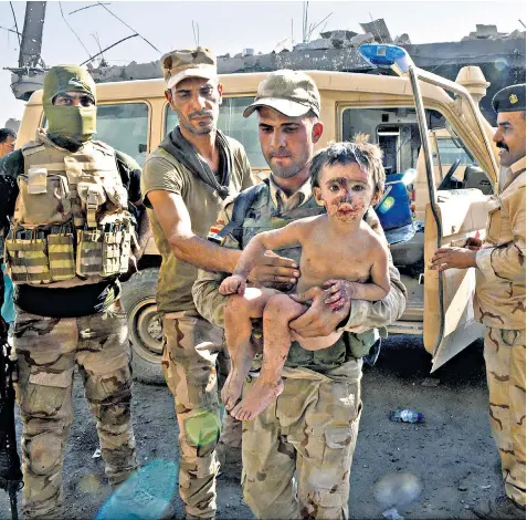  ??  ?? A young boy who is believed to be Chechen was found by Iraqi soldiers eating scraps of raw meat from the ground. The soldiers said they killed an Isil fighter nearby