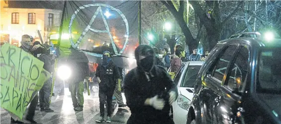  ?? MAURICIO NIEVAS ?? Anarquista­s. Uno de los grupos que atacó la Gobernació­n bonaerense, el jueves a la noche, camina por las calles platenses.