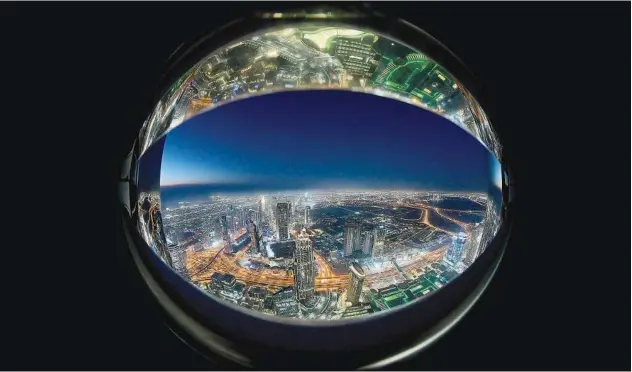  ?? Agence France-presse ?? This picture taken with a fish-eye lens shows a view of the Dubai City skyline as seen from the Burj Khalifa.