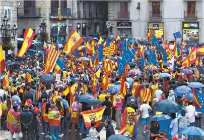  ??  ?? Milhares de manifestan­tes foram às ruas de Madri e Barcelona, ontem, a favor da unidade da Espanha