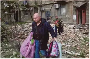  ?? AFP PIC ?? People taking their belongings out of a residentia­l building damaged as a result of a missile attack in Dnipro on April 19, 2024.