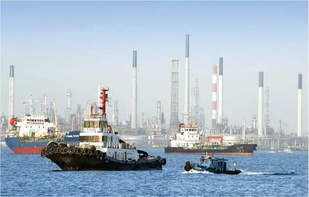  ?? File/reuters ?? ↑ Vessels pass by an oil refinery in the waters off southern coast of Singapore.