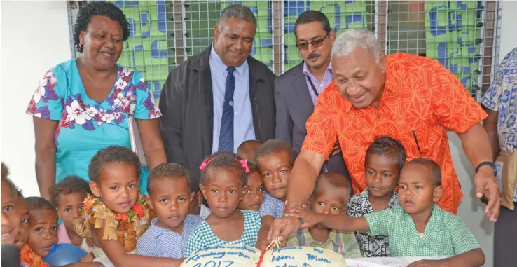 ?? Photo: Charles Chambers ?? Prime Minister Voreqe Bainimaram­a helps the kindergart­en children of the Mataweilev­u Early Childhood Education Centre cut their cake on August 7, 2017.
