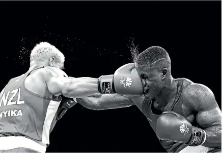  ?? GETTY IMAGES ?? New Zealand heavyweigh­t boxer David Nyika connects with a right to the face of England’s Cheavon Clarke in their semifinal on the Gold Coast. Some say it is time for the Commonweal­th Games to be delivered a knockout blow.