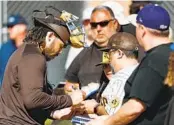  ?? MEG MCLAUGHLIN U-T ?? Padres catcher Luis Campusano signs autographs for fans during a spring training practice Sunday.