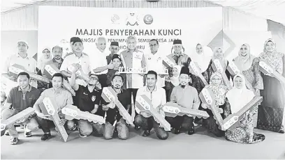  ?? — Gambar Bernama ?? TERIMA KUNCI: Ahmad Zahid (tengah) bergambar bersama para penerima Pangsapuri Desa Jaya pada Majlis Penyerahan Kunci Pangsapuri Penempatan Semula Desa Jaya di Johor Bahru semalam. Hadir sama Mohamed Khaled dan Shahrir.