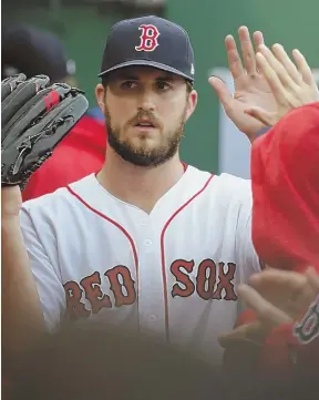  ?? STAFF PHOTO BY JOHN WILCOX ?? JOB WELL DONE: Drew Pomeranz gets high fives in the dugout after being relieved in the seventh inning of the Red Sox’ win yesterday.