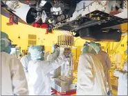  ?? NASA — JPL-CALTECH VIA AP ?? Engineers and technician­s insert sample tubes into the belly of the Perseveran­ce Mars rover at the Kennedy Space Center in Florida on May 20.