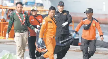  ?? — Reuters photos ?? Rescue workers carry a body bag at the Tanjung Priok port in Jakarta, Indonesia.