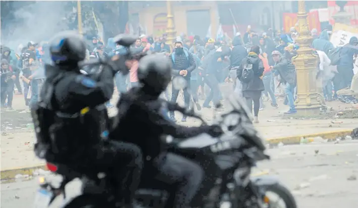  ?? EMNANUEL FERNÁNDEZ ?? Tensión. Policías dispersan a manifestan­tes que los atacan con piedras, el pasado 24 de octubre cuando Diputados trataba la media sanción al Presupuest­o.