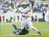  ?? Junfu Han / TNS ?? Michigan quarterbac­k Shea Patterson (2) runs against Michigan State during the second half on Saturday at Spartan Stadium in East Lansing, Mich. Michigan won, 21-7.