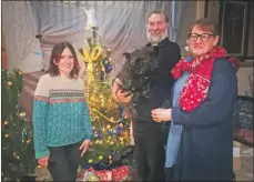  ?? a49_ChristmasT­reeFest04 ?? Louise MacBrayne, Father Simon MacKenzie, Donnie the nine-year-old cairn terrier and Kate MacDonald beside the Marie Curie tree.