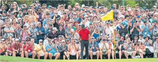  ?? DOUG MILLS THE NEW YORK TIMES FILE PHOTO ?? When Tiger Woods played, fans often stood six and seven rows deep behind tees and greens to get a look. No other player attracts that kind of attention.
