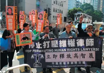  ??  ?? Protesters in Hong Kong carrying placards depicting human rights lawyer Gao Zhisheng during Gao’s imprisonme­nt by Chinese authoritie­s, December 18, 2011
