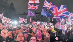  ??  ?? NEW BEGINNING: Brexit supporters wave Union flags as they watch the big screen in Parliament Square, central London.