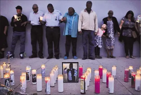  ?? Katie Falkenberg Los Angeles Times ?? MOURNERS gather at a vigil in Hawthorne for Denise Berry, 44, who was with her son when she was shot. An officer killed her assailant.