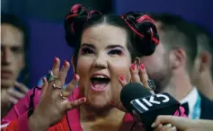  ?? (Pedro Nunes/Reuters) ?? NETTA BARZILAI speaks into a Kan microphone earlier this month, during a news conference following her Eurovision win in Lisbon.