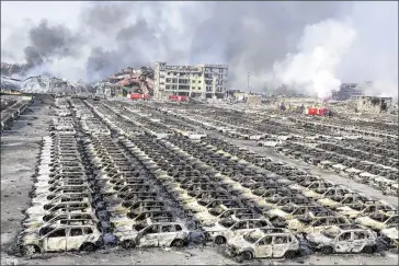  ?? NG HAN GUAN / ASSOCIATED PRESS ?? Smoke billows Thursday from the site of an explosion that reduced a parking lot filled with new cars to charred remains at a warehouse in the Chinese port city of Tianjin. Fatalities from the blast, at a company licensed to store hazardous chemicals,...