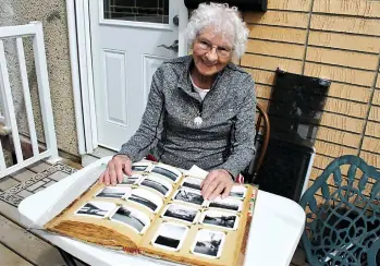  ??  ?? Moose Jaw resident Gwen Boivin, 85, flipped through the photo album her mother made that’s filled with family memories from growing up in the Dirty Thirties, World War II, and beyond.