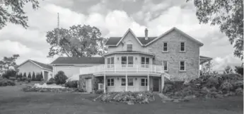  ?? CHESTNUT PARK REAL ESTATE LTD. PHOTOS ?? The home’s historic-looking front exterior has a stone facade, a veranda and a central peaked roof.