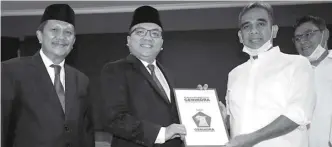  ?? MIFTAHUL HAYAT/JAWA POS ?? PENGUSUNG: Sekretaris Jenderal DPP Partai Gerindra Ahmad Muzani (dua dari kanan) memberikan surat rekomendas­i kepada Denny Indrayana (dua dari kiri) dan Difriadi Darjat (kiri) di kantor DPP Gerindra, Jakarta, Senin (3/8).