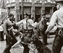  ?? Bill Hudson / Associated Press file photo ?? In this May 3, 1963, photo, police dogs attack a 17-year-old Black civil rights activist during a demonstrat­ion in Birmingham, Ala.