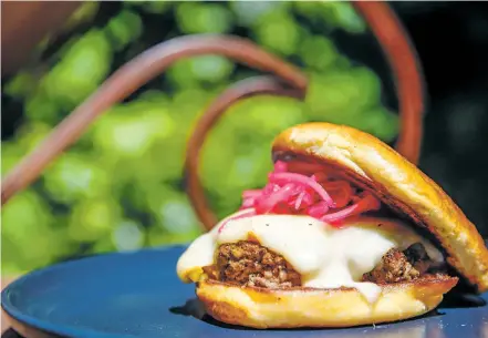  ?? PHOTOS BY GABRIELA CAMPOS THE NEW MEXICAN ?? Market Steer Steakhouse’s half-pound burger, the ‘Johnny C,’ topped with muenster cheese, green chile jam and pickled red onions served on a brioche bun from Boultawn’s Bakery. The burger is one of the finalists at Saturday’s Green Chile Cheeseburg­er Smackdown.