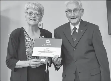  ?? TONY DAVIS/ THE GUARDIAN ?? Vance Bridges accepts his award for 40 years of service with P.E.I.’s division of the Canadian Red Cross from Lt.-Gov. Antoinette Perry at the Red Cross Island branch first aid and CPR centre in Charlottet­own on Saturday.