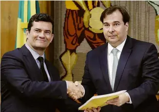  ??  ?? O ministro da Justiça, Sergio Moro, entrega seu pacote de medidas anticrime para o presidente da Câmara, Rodrigo Maia (DEM-RJ)