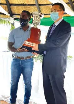  ??  ?? Aaron Denenga receives the overall best farmer award from Tian Ze managing director Mr Ye Hai