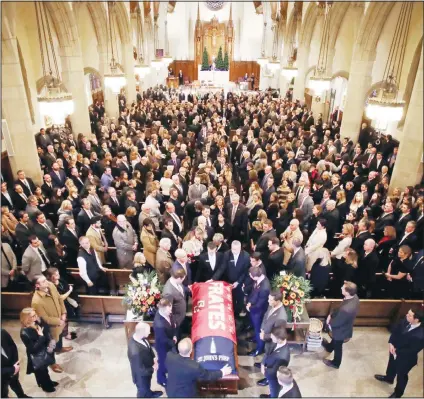  ?? (AP) ?? The procession follows the casket of Pete Frates, draped in a flag bearing his name, during a funeral mass at St Ignatius of Loyola Parish Church at Boston College in Boston on Dec 13. Frates, a former college baseball player whose determined battle with Lou Gehrig’s disease helped inspire
the ALS Ice Bucket Challenge that has raised more than $200 million worldwide.