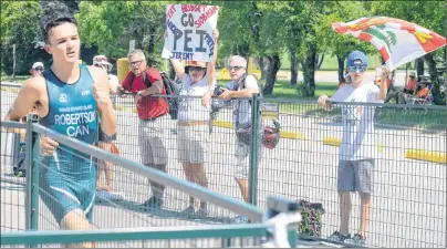  ?? JASON MALLOY/THE GUARDIAN ?? Family members show their support as Charlottet­own’s Nick Robertson starts his final lap of the running component of the triathlon Monday at the Canada Games.