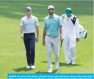  ?? — AFP ?? AUGUSTA: File photo of Rory McIlory of Northern Ireland walks with Dustin Johnson of the United States during a practice round prior to The Masters at Augusta National Golf Club on April 8, 2019 in Augusta, Georgia.