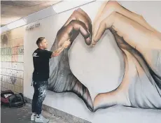  ??  ?? Nathan Murdoch at work on the Peterborou­gh mural that attracted worldwide attention