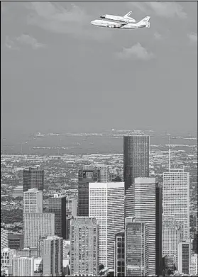  ?? SMILEY N. POOL / HOUSTON CHRONICLE ?? The space shuttle Endeavour, carried atop NASA’s 747 Shuttle Carrier Aircraft, passes over the downtown Houston skyline during a flyover Wednesday.