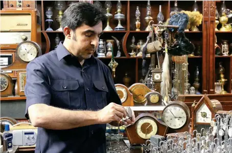  ?? AN photo by Saadullah Akhter ?? Gul Kakar, who has collected thousands of ancient clocks from around the world, holds a pocket watch at his museum in Quetta, Pakistan.
