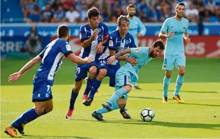  ??  ?? stopping him: Barcelona’s Lionel Messi is held back by Alaves’ Tomas Pina during their La Liga match on Saturday. — Reuters