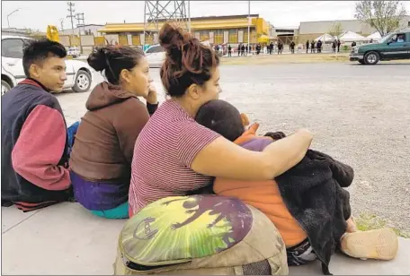  ?? Molly Hennessy-Fiske Los Angeles Times ?? SALVADORAN migrant Merlin Linares Rodriguez, 23, second from right, and son Jose Garcia Linares, 7, wait across the street from the shelter in Piedras Negras, Mexico, this week with siblings Cristiano Maradiaga Herrera, 15, and Irisujapa Maradiaga Herrera, 14.