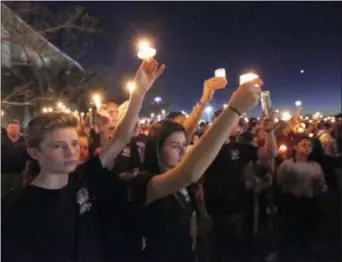  ?? ASSOCIATED PRESS ?? Attendees hold up their candles at a candleligh­t vigil on Feb. 15 for the victims of the shooting at Marjory Stoneman Douglas High School.