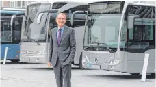  ?? FOTO: DPA ?? Daimlers Buschef Hartmut Schick vor Bussen der Marken Mercedes-Benz und Setra: Jetzt wird die Produktion neu geordnet.