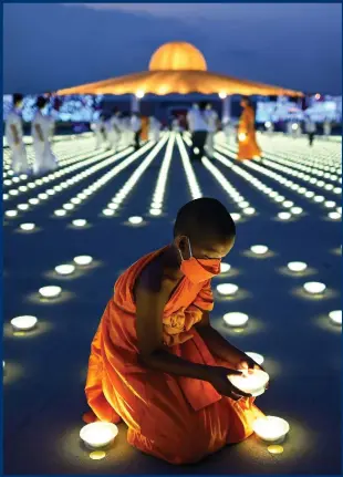  ?? Photograph: Manan Vatsyayana/AFP ?? A young Buddhist monk arranges a LED light as part of Earth Day celebratio­ns at the Wat Dhammakaya Buddhist temple in Pathum Thani province, north of Bangkok, on Friday