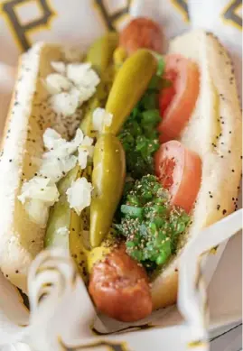  ?? Alexandra Wimley/Post-Gazette photos ?? Fans will have a variety of new food options at PNC Park this season, including the Smoky BBQ & Blue Cheese Burger, left, from the new burgercent­ric Cannonball Stand, and a 7-inch Chicago Dog, from the new Deli Dogs stand.