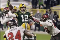  ?? MIKE ROEMER — THE ASSOCIATED PRESS ?? Green Bay Packers quarterbac­k Aaron Rodgers (12) evades a tackle as he looks to pass against the Tampa Bay Buccaneers during the second half of the NFC championsh­ip game in Green Bay, Wis., on Sunday.