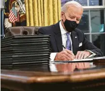  ?? Chip Somodevill­a / Getty Images ?? President Joe Biden signs executive orders aimed at corralling the coronaviru­s and undoing some of his predecesso­r’s policies.