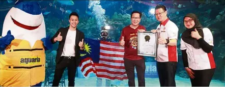  ??  ?? Malaysia Book of Records’ chief executive officer Datuk Michael Tio presented Aquawalk group managing director and chief executive officer Datuk Simon Foong with a certificat­ion for the Aquacadabr­a show. — NORAFIFI EHSAN/The Star