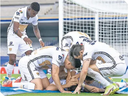  ??  ?? Los felinos festejan la anotación de Juan Ignacio Dinenno, quien selló el triunfo de Pumas sobre Puebla.